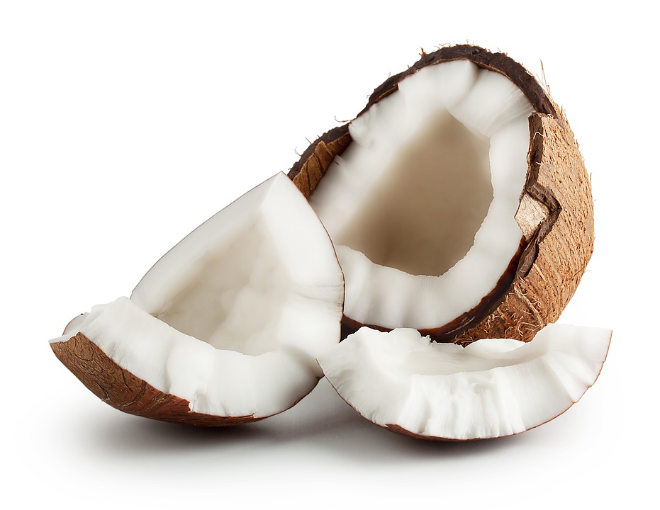 The image displays a coconut on a surface, possibly outdoors. 