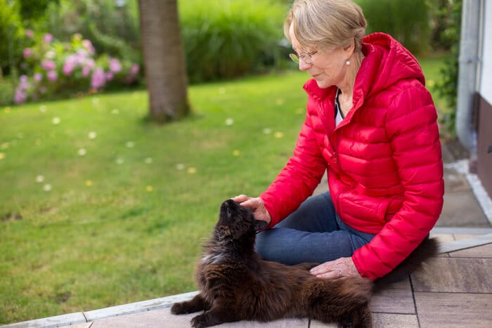 A person searching outdoors with a concerned expression, likely looking for a lost cat. 