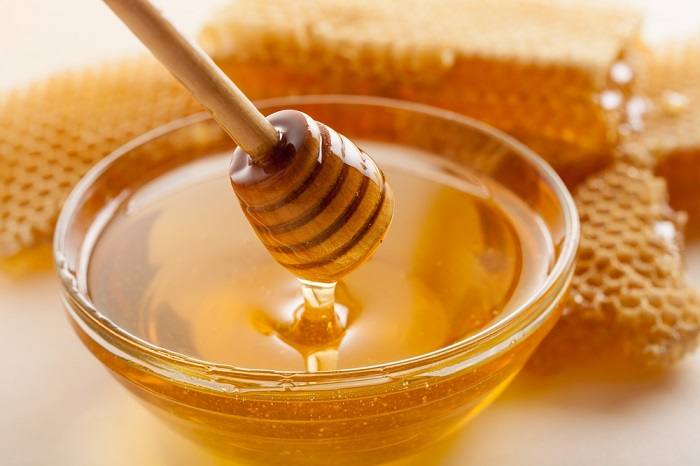 A jar of honey, showcasing a natural sweetener that prompts discussions about its suitability for cats' diets.