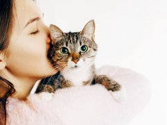 woman kisses and hugs cat